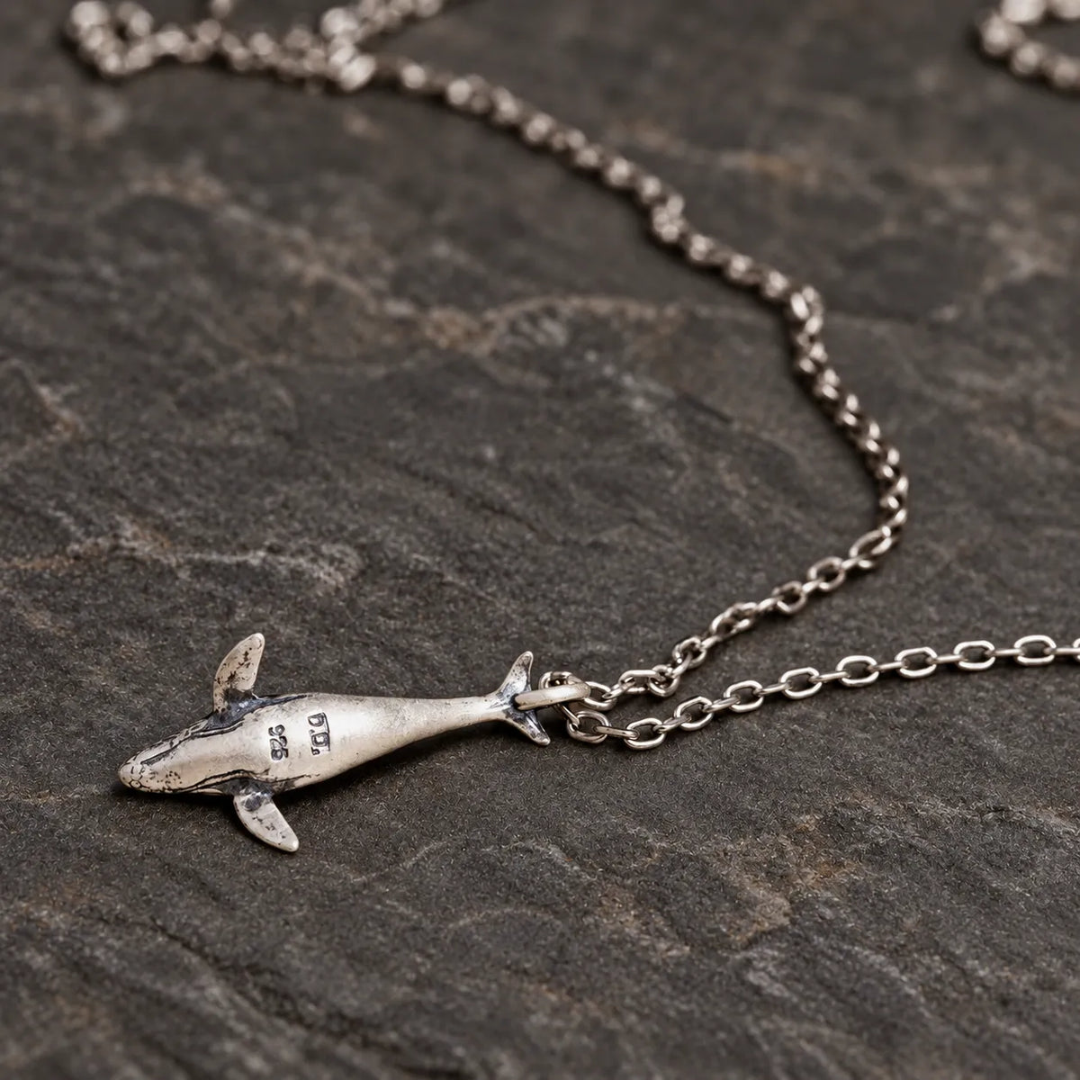 Back view of the humpback whale pendant showing its sterling silver hallmark