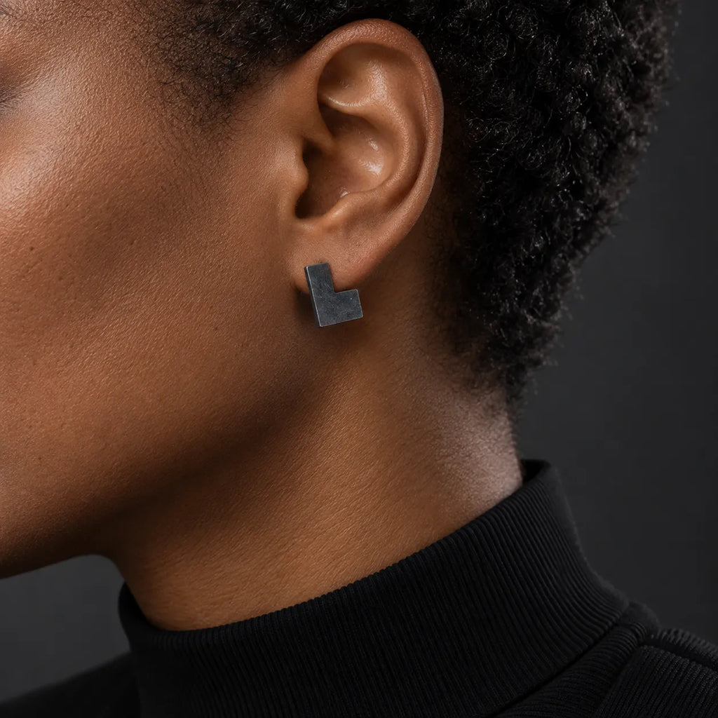 Black woman wearing a 16 mm black oxidized open square stud earring