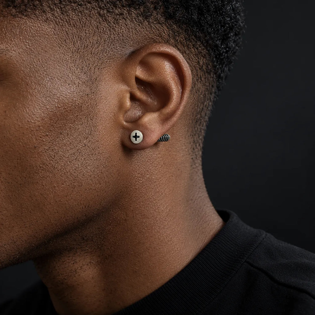 Black male model wearing a 7 mm oxidized sterling silver cross-slot screw stud earring