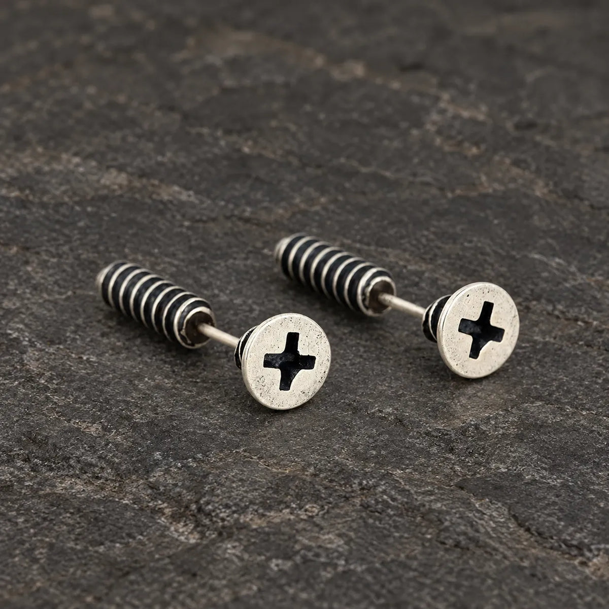 Angled view of screw stud earrings showing their round fronts and tapered backs