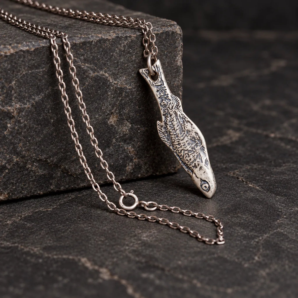 Fishbone pendant hanging naturally from its tail hole and jump ring