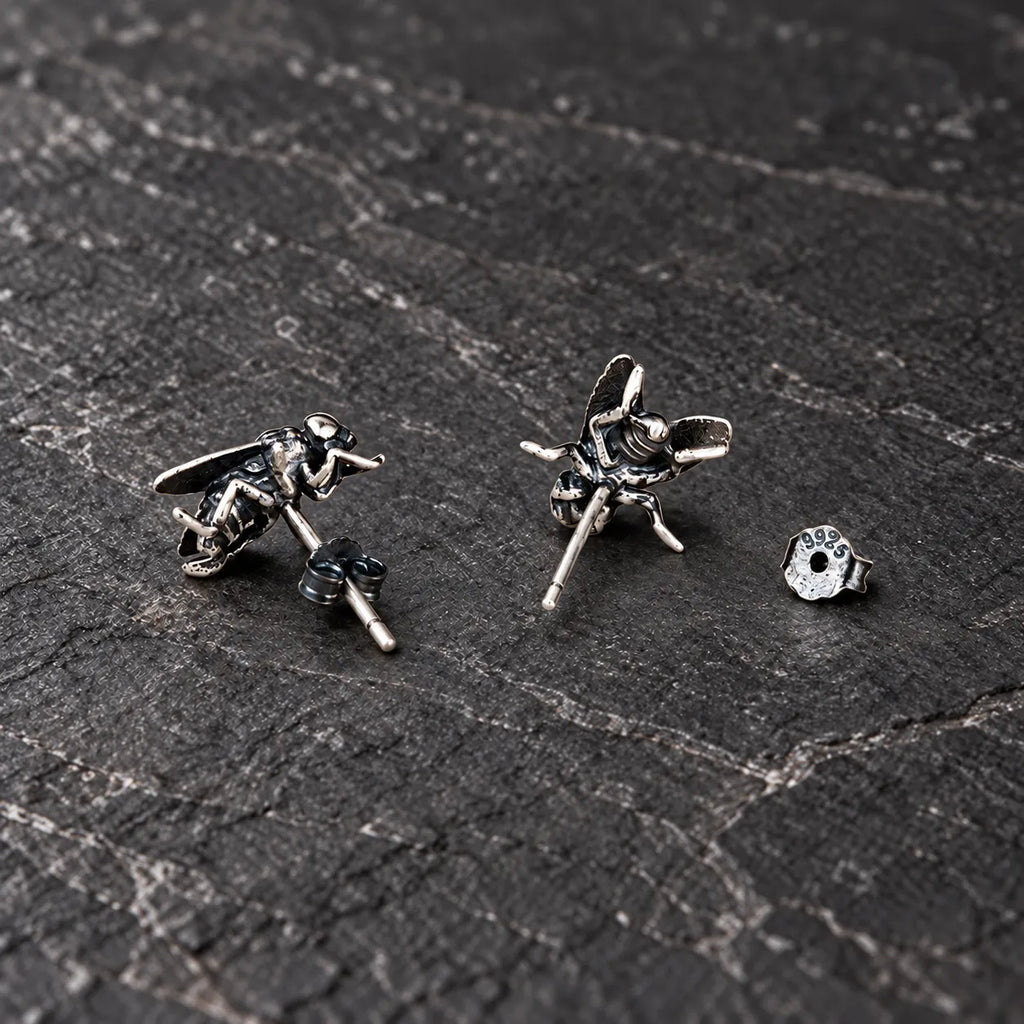 Rear angled view of oxidized silver fly stud earrings showing their straight posts and butterfly backs