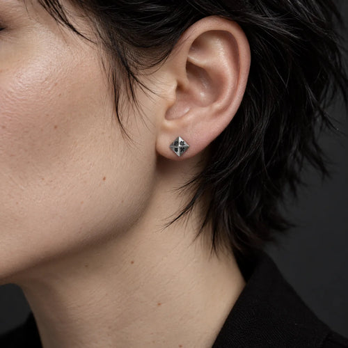 Five millimeter four suits pyramid stud earring worn by a male model