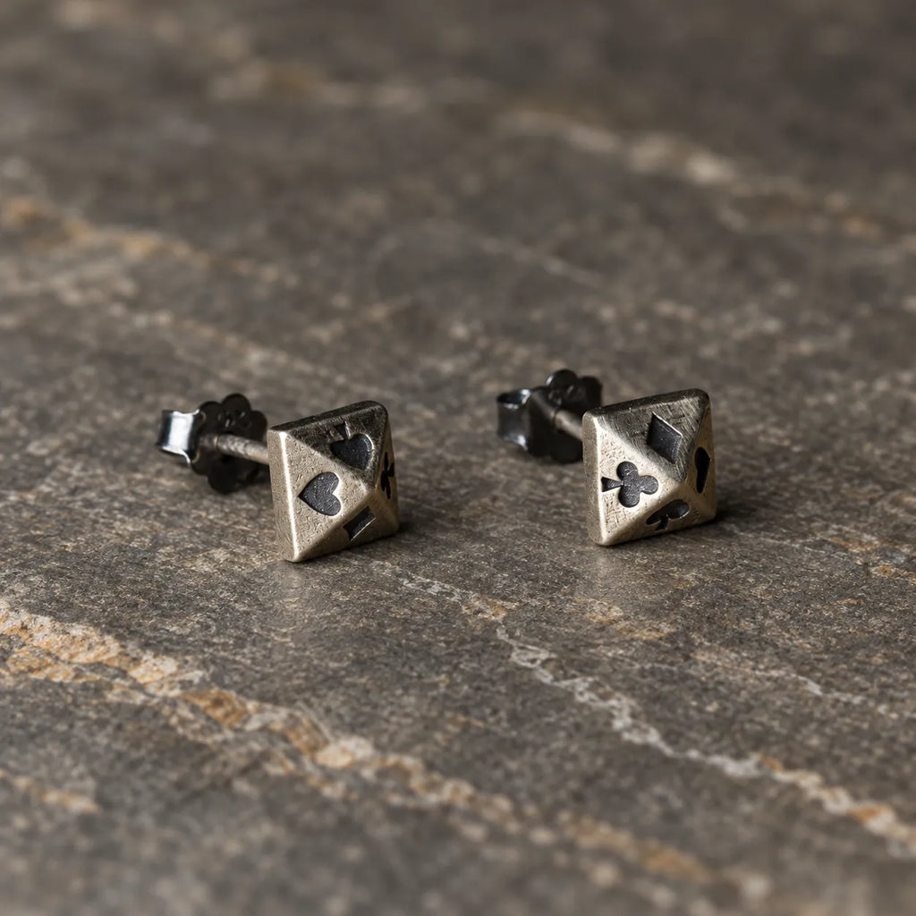 Angled view of four suits pyramid stud earrings showing their raised geometric facets