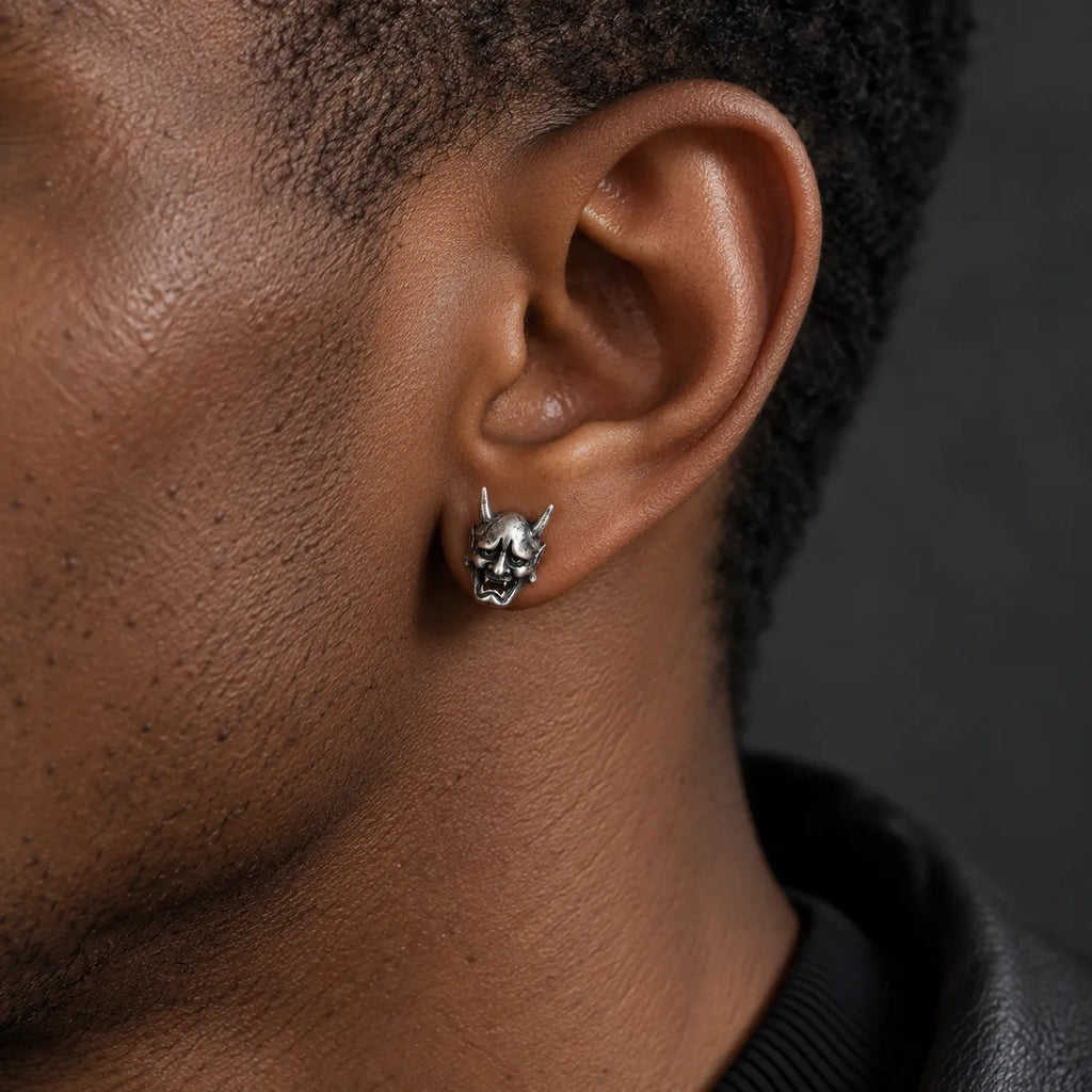 Hannya mask stud earring worn to show its actual 9 by 14 mm size