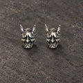 Pair of oxidized sterling silver Japanese Hannya mask stud earrings on dark stone
