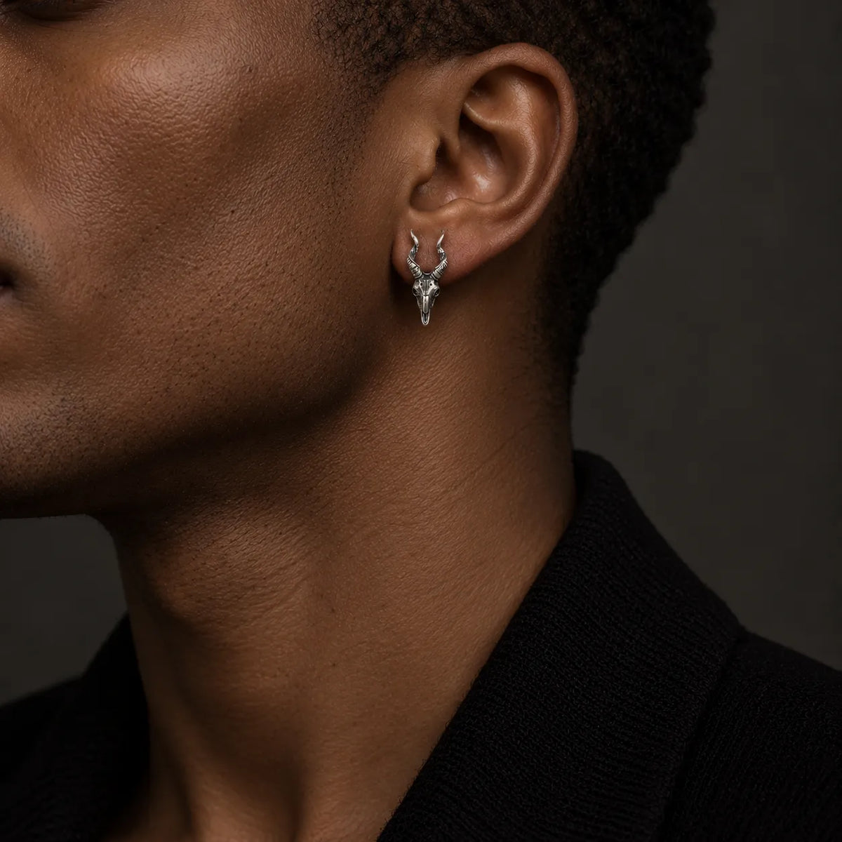 Horned skull stud earring worn at its actual 7 × 18 mm size
