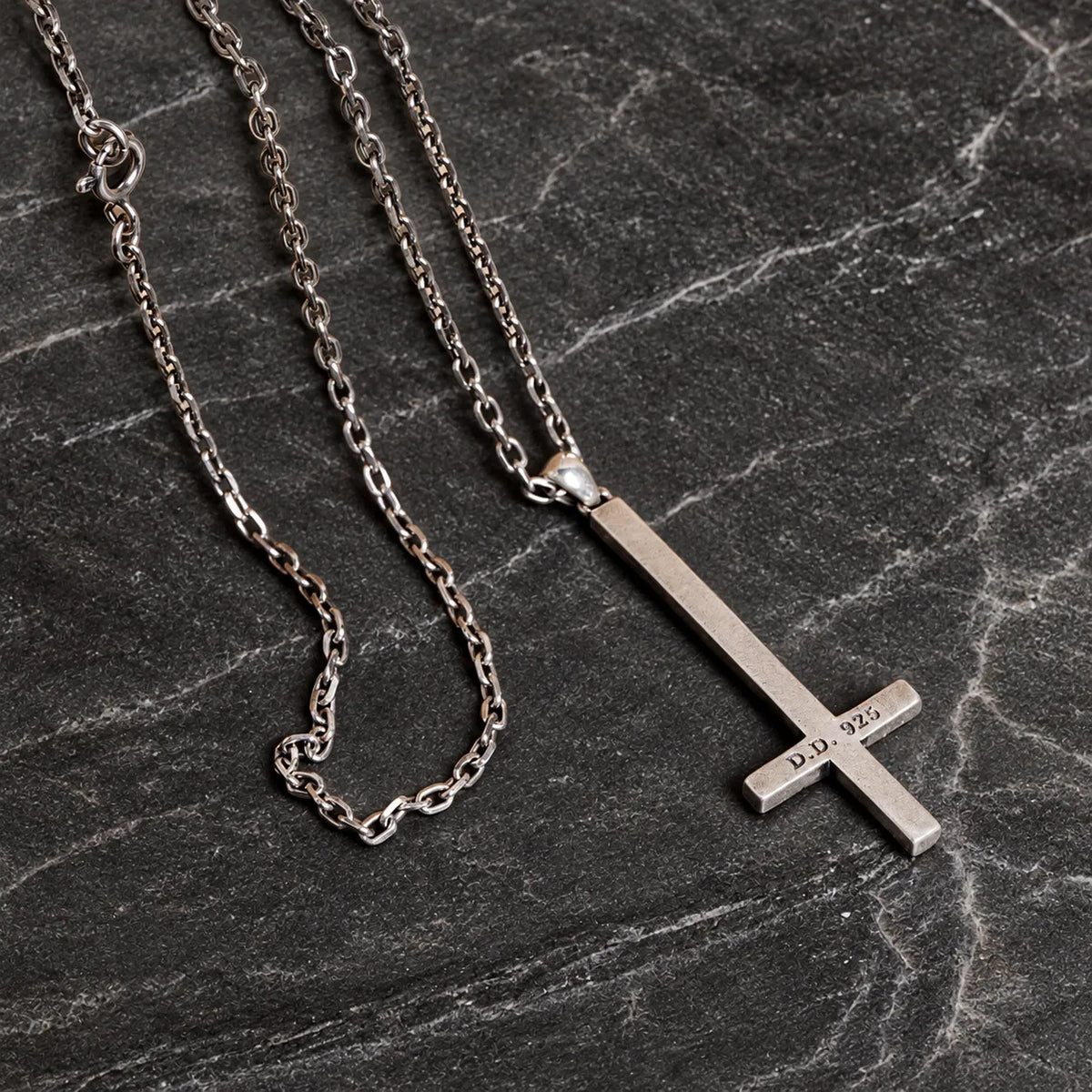 Back view of an inverted cross pendant with its articulated bail and optional silver chain