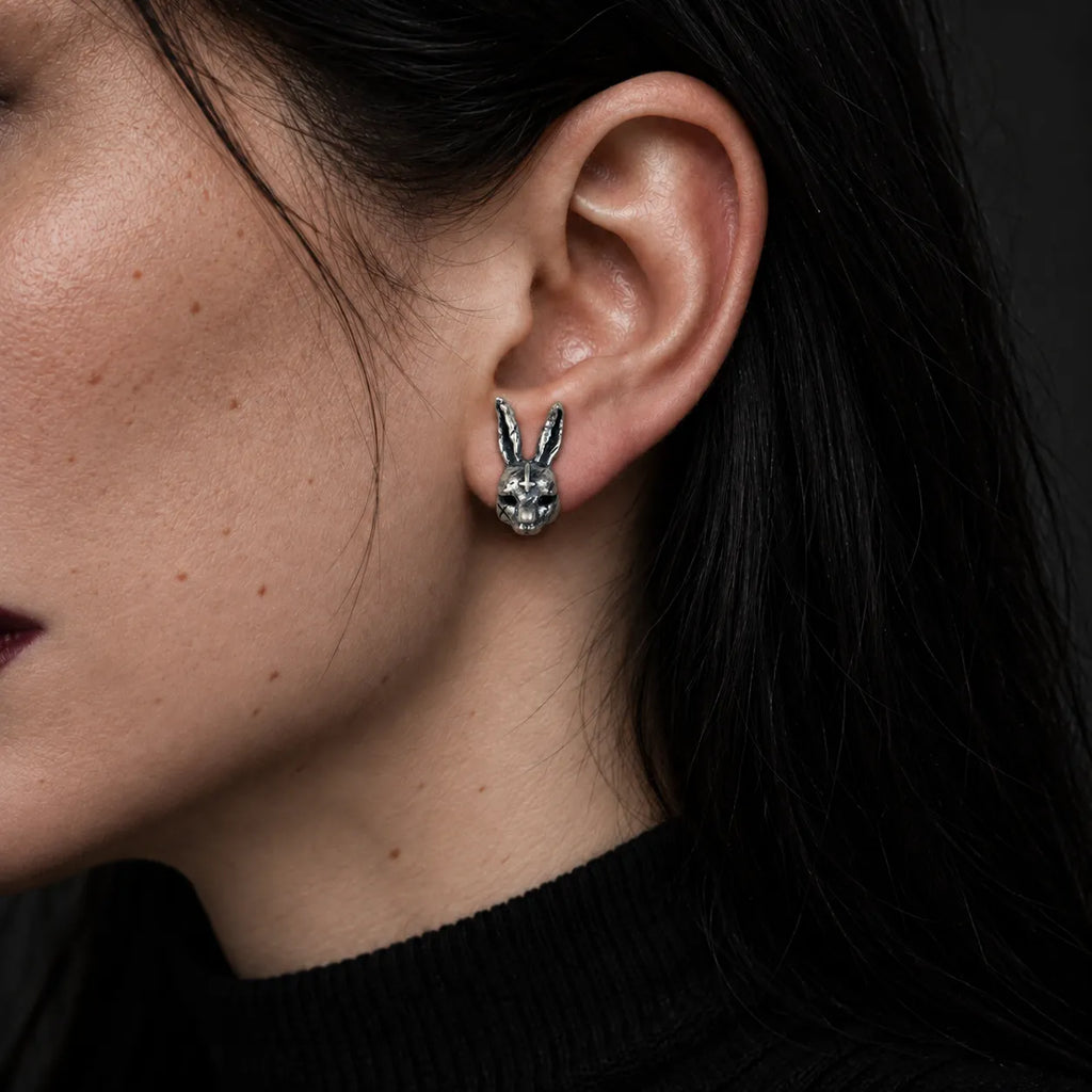 Inverted cross rabbit stud earring worn on an ear to show its 8 by 17 mm size