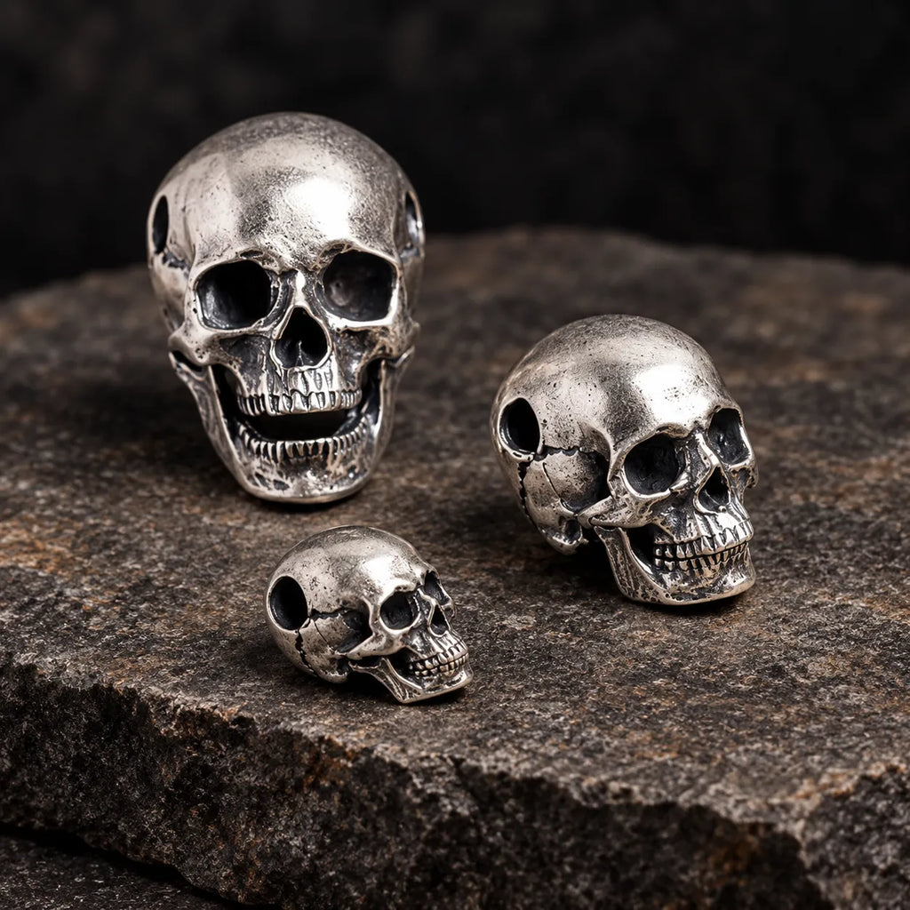 Three larger articulated skull pendant sizes shown from front, three-quarter and side angles