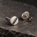 Angled view of round line disc earrings showing their straight posts and butterfly backs