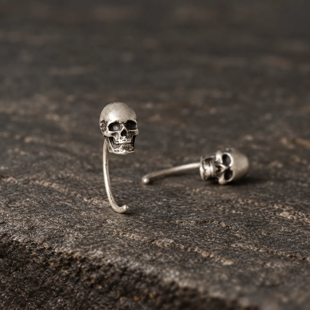 Mini skull earrings shown upright and lying flat to display their curved wire structure