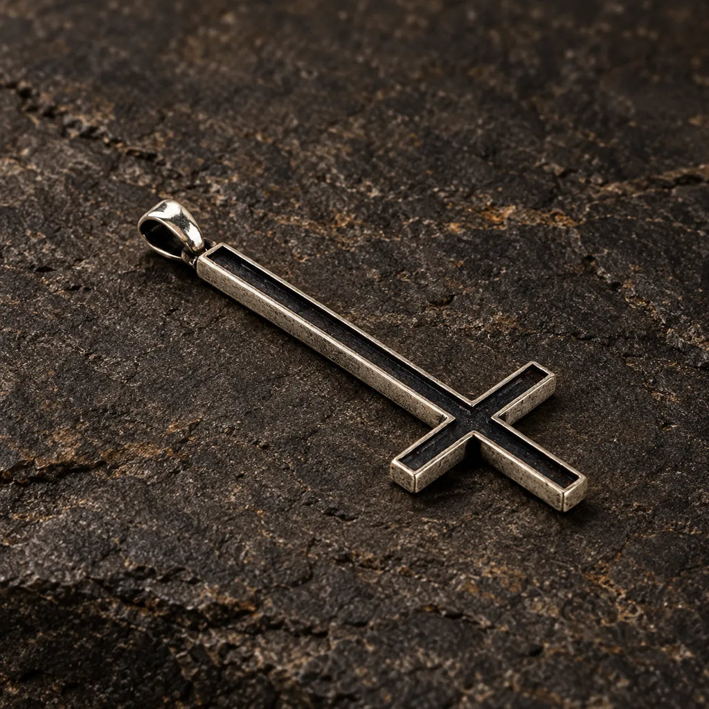 Three-quarter view of an oxidized silver inverted cross pendant showing its recessed face and thickness