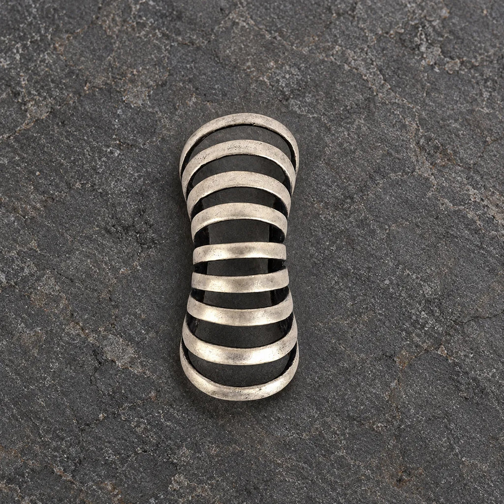 Top view of an oxidized silver rib ear cuff showing its tapered open framework
