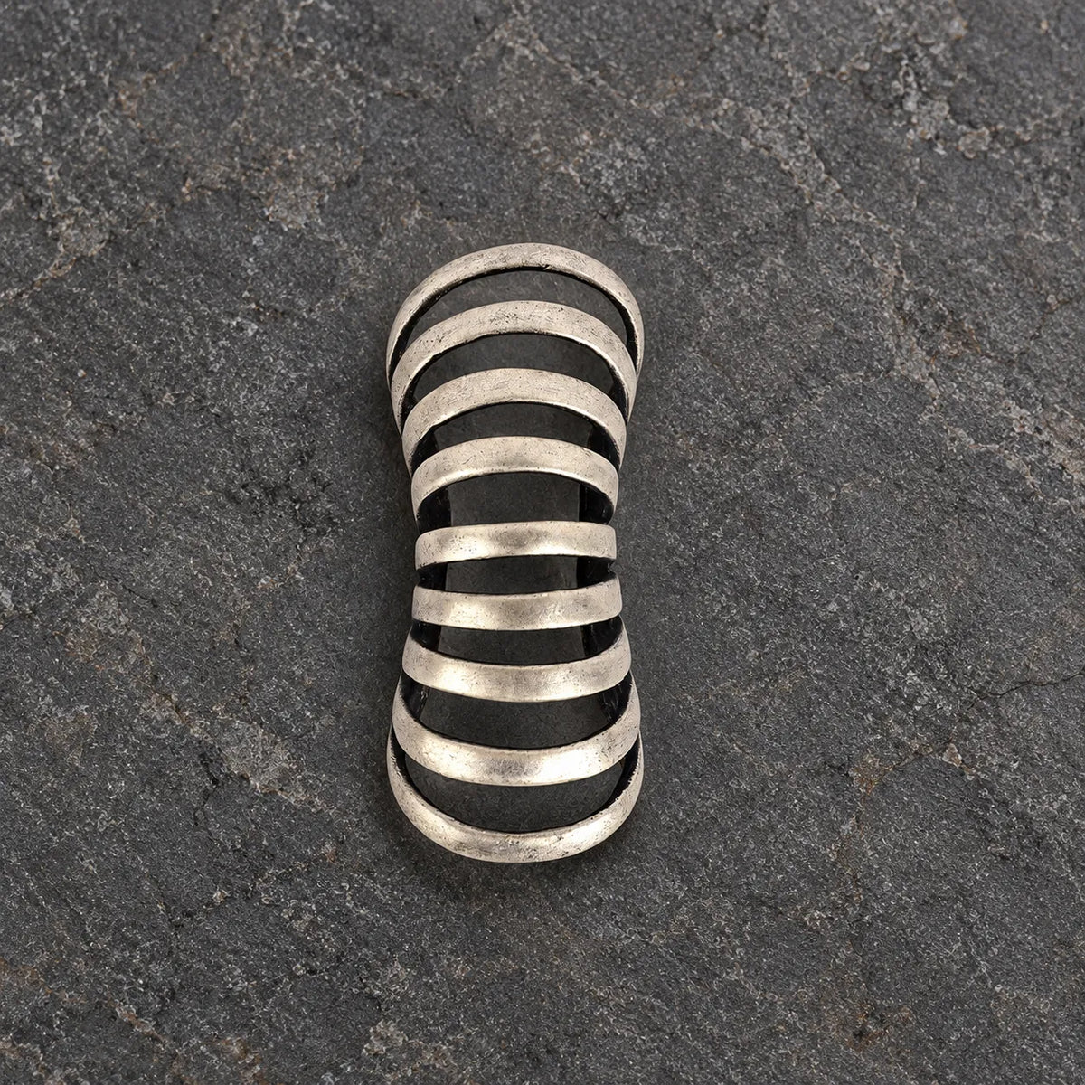 Top view of an oxidized silver rib ear cuff showing its tapered open framework