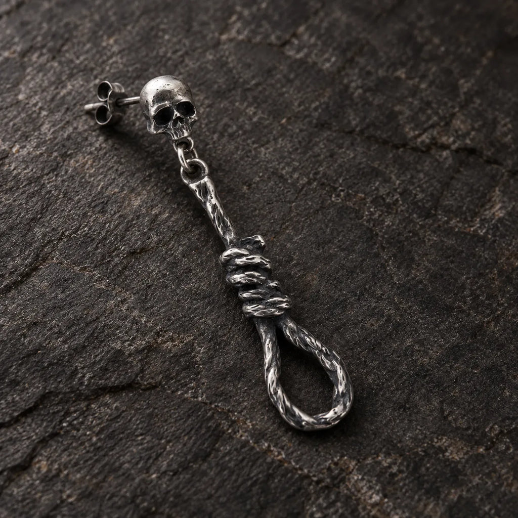 Close-up of a skull and noose earring showing its articulated rings, rope texture and wrapped knot
