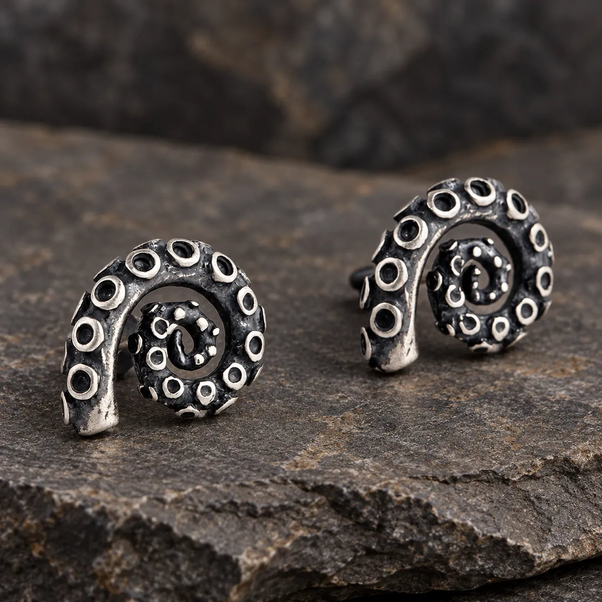 Angled view of oxidized silver tentacle stud earrings showing their sculpted suction cups