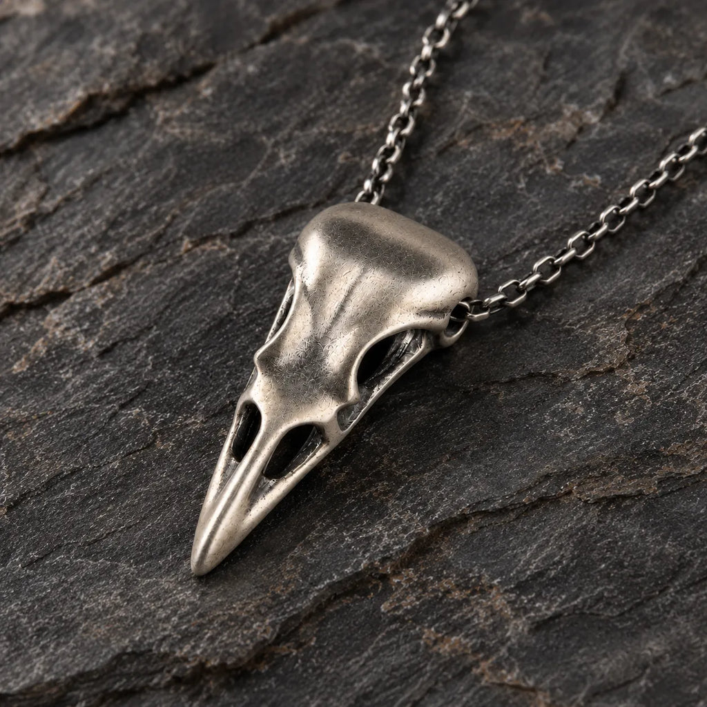 Close angled view of the raven skull pendant showing its concealed integrated chain passage