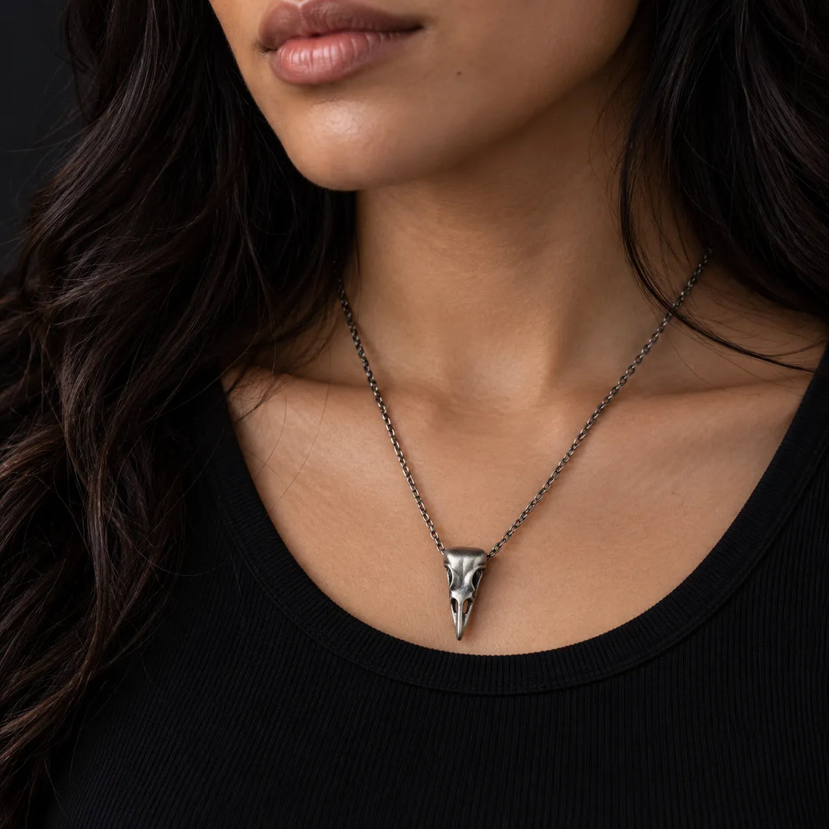 Raven skull pendant worn at its actual 13 by 29 mm size on an optional 2.0 mm chain