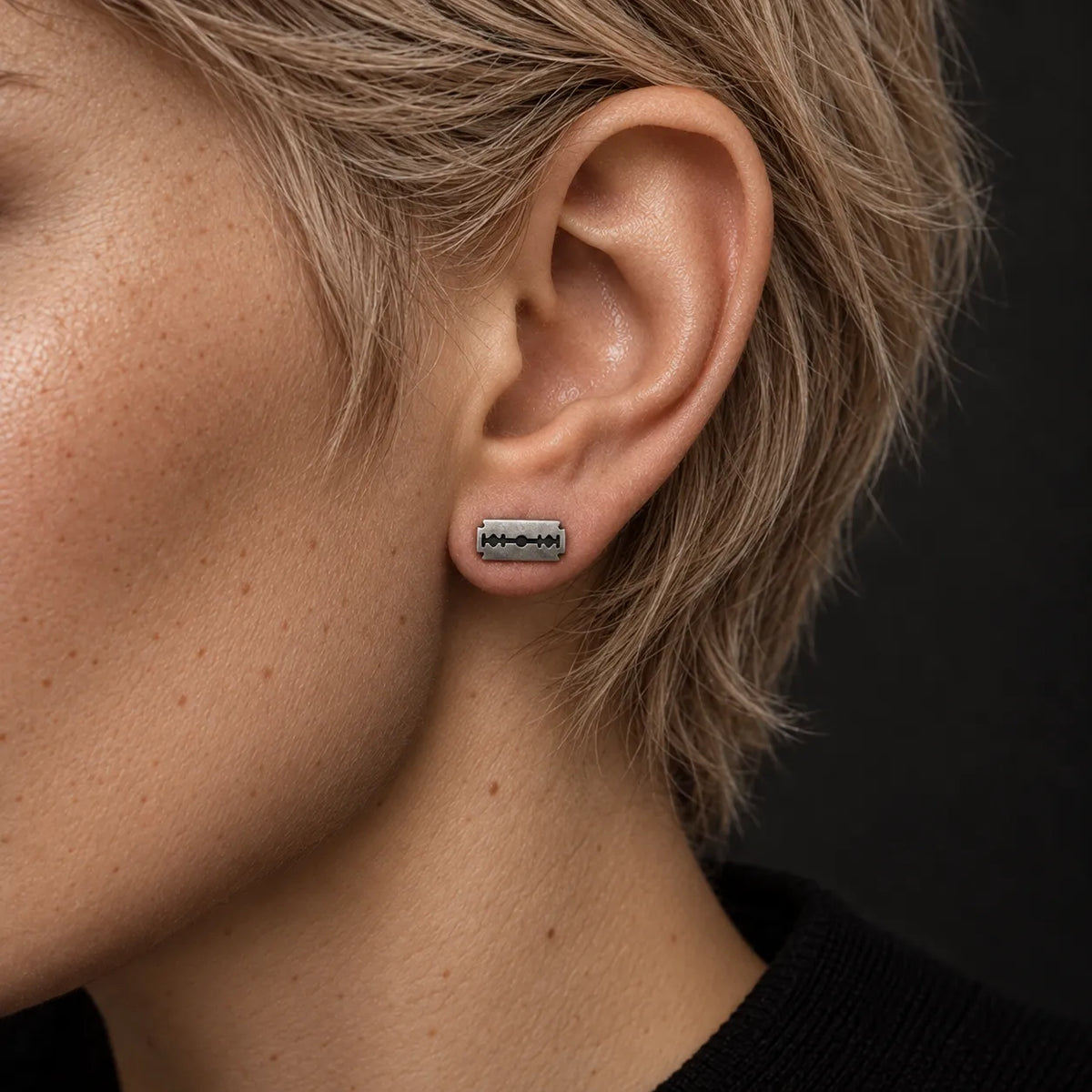 Small silver razor blade stud earring worn horizontally to show its 11 mm width