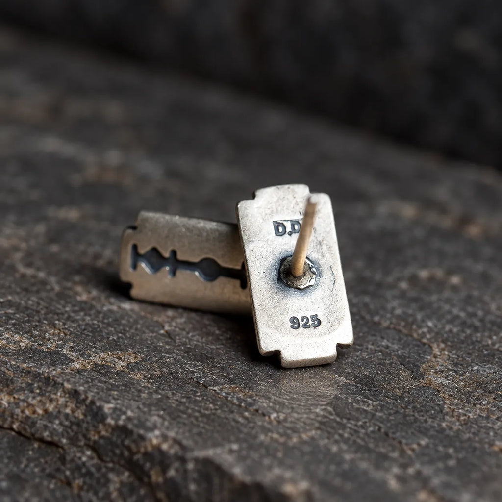 Back view of a razor blade stud earring showing its central post and 925 stamp