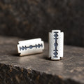 Low-angle view of silver razor blade stud earrings showing their flat construction