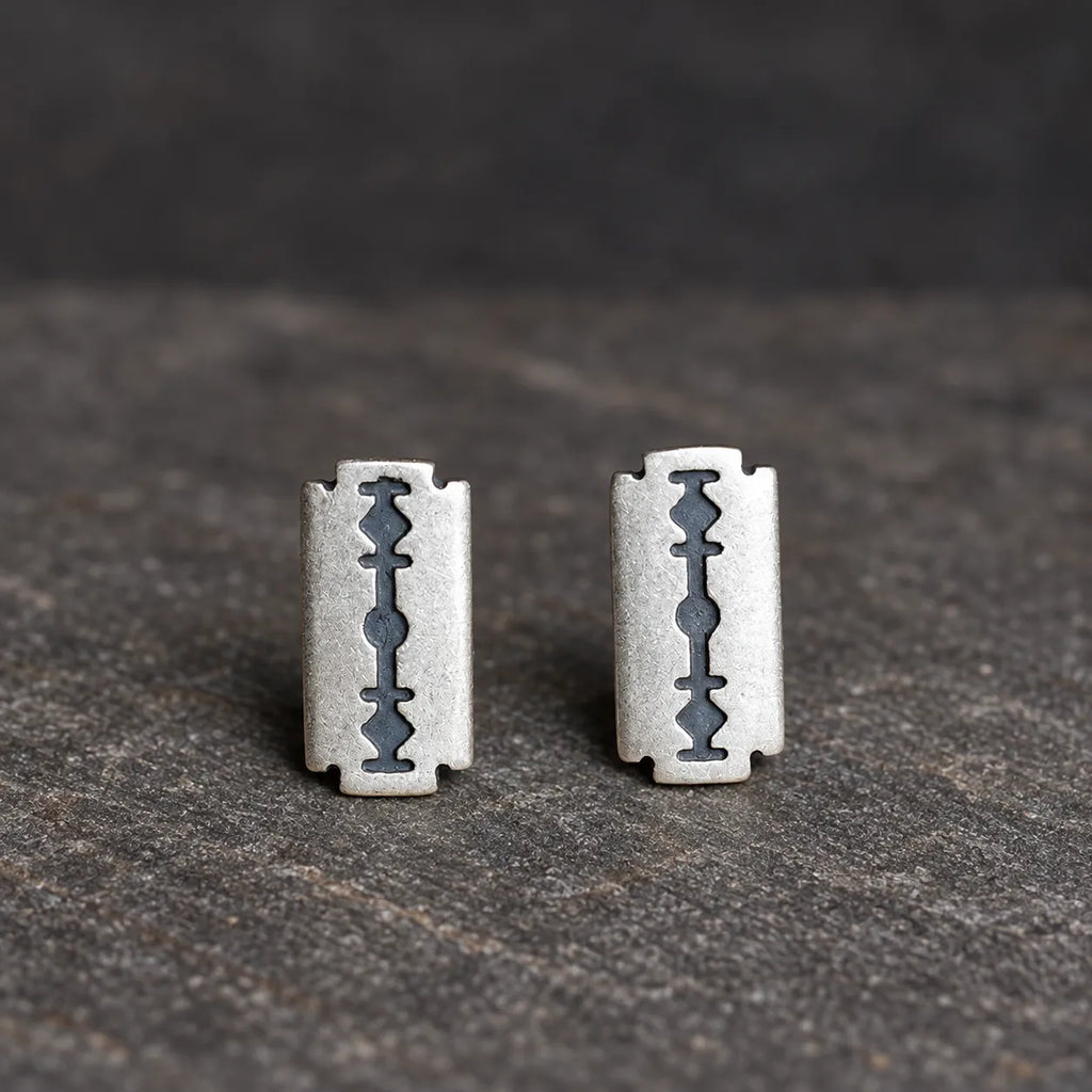 Front view of two oxidized silver razor blade stud earrings positioned vertically