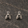 Pair of oxidized sterling silver fly stud earrings viewed from the front
