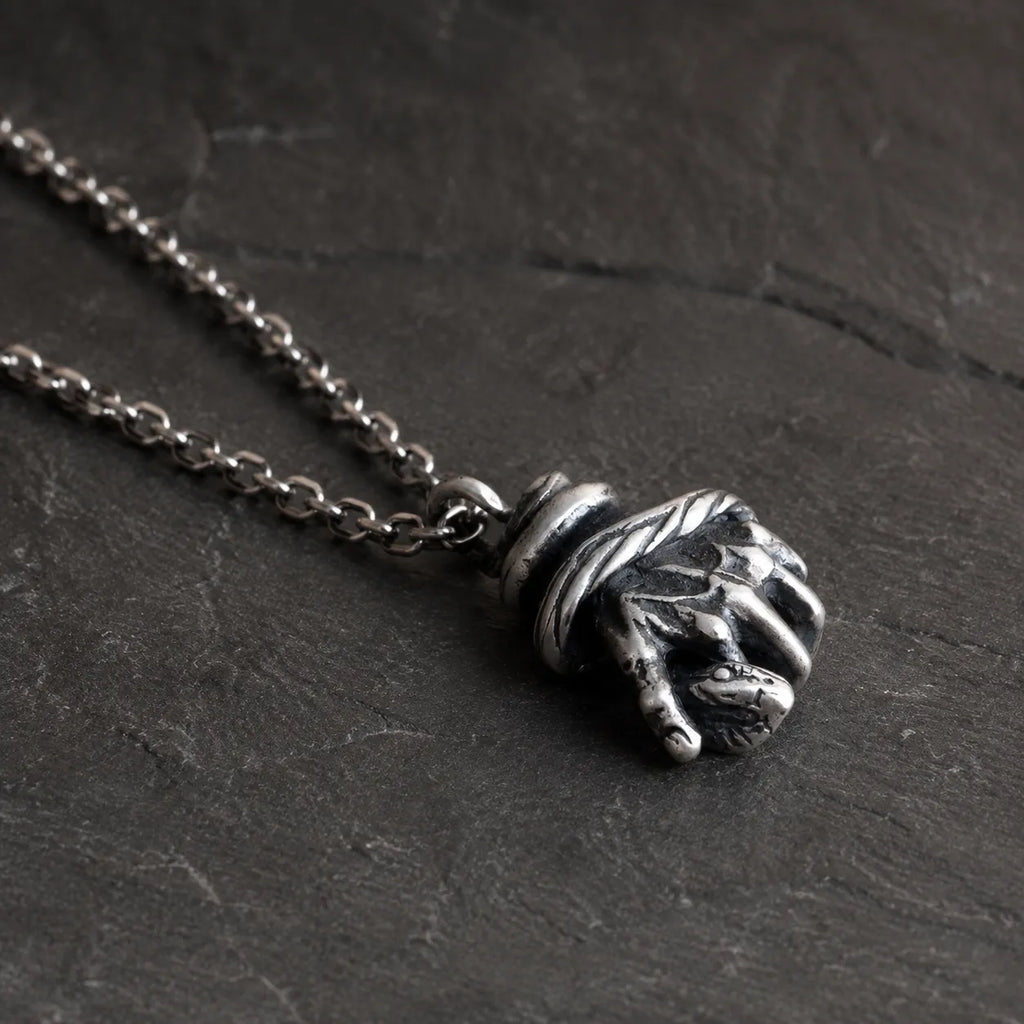 Low side angle of the serpent hand pendant showing its sculptural depth