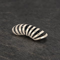 Oxidized 925 sterling silver skeletal rib ear cuff on dark stone