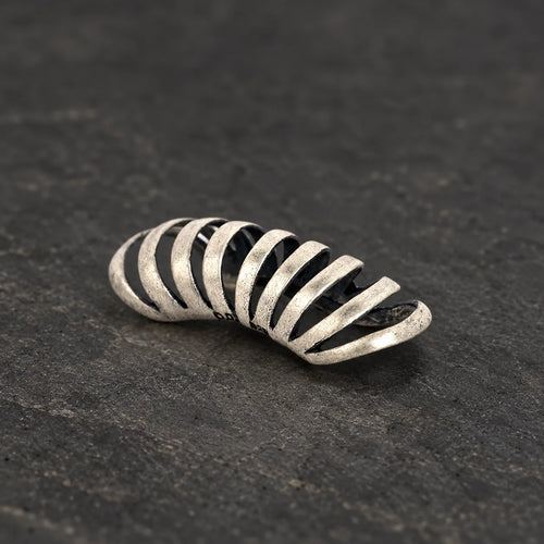 Oxidized 925 sterling silver skeletal rib ear cuff on dark stone