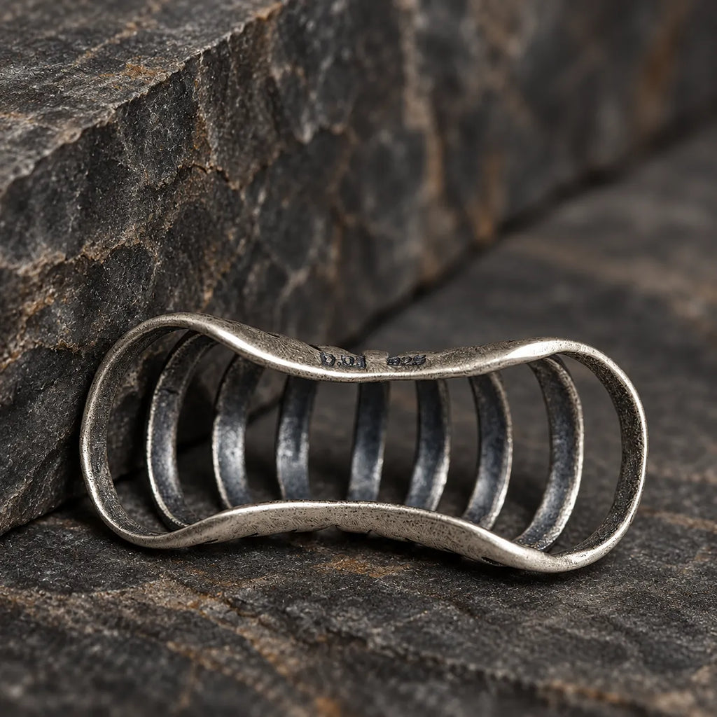 Inner view of an oxidized silver skeletal rib ear cuff showing its open slip-on frame