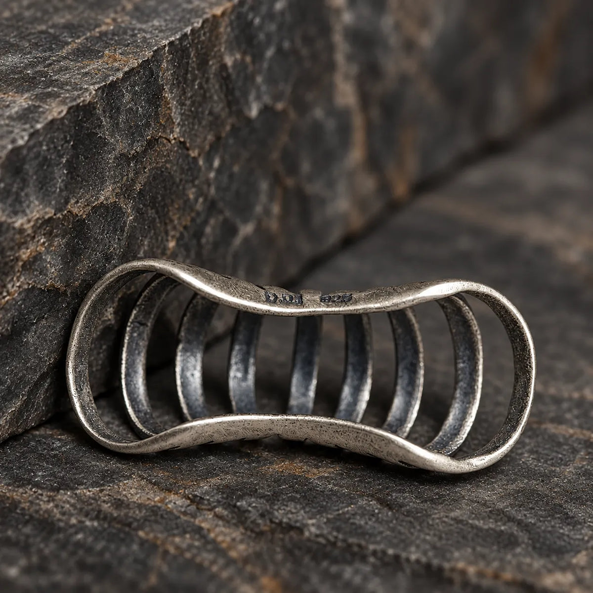 Inner view of an oxidized silver skeletal rib ear cuff showing its open slip-on frame