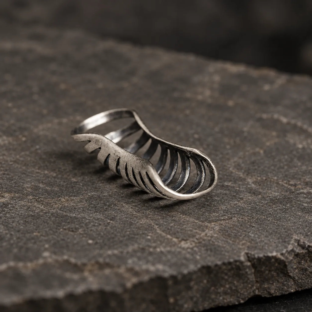 Low side angle of an oxidized silver skeletal rib ear cuff showing its curved open structure