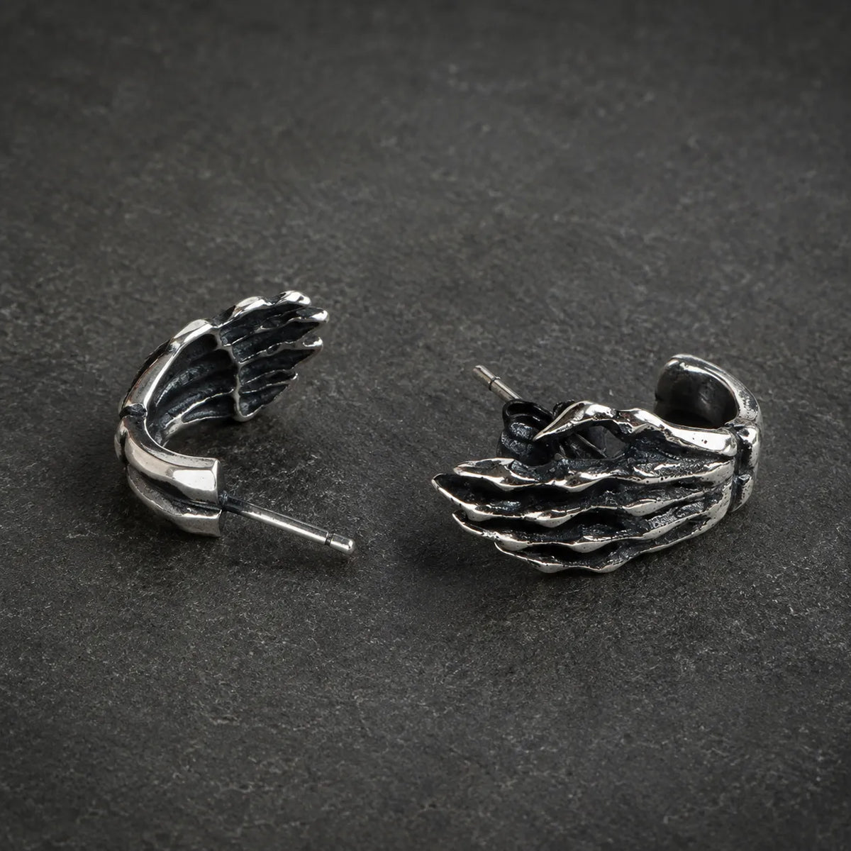 Angled view of skeleton hand stud earrings showing their sculpted depth and straight posts