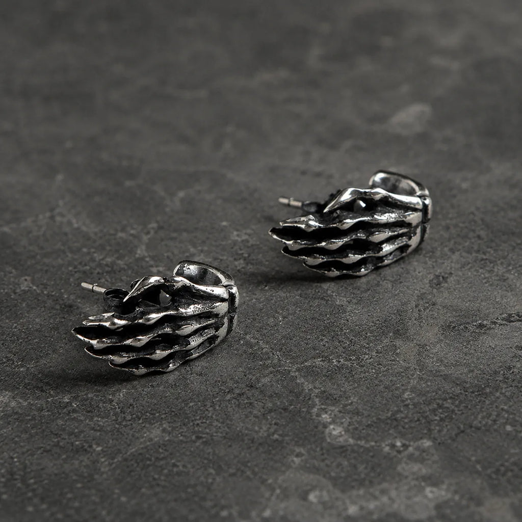 Side view of skeleton hand stud earrings showing their curved shape and straight posts
