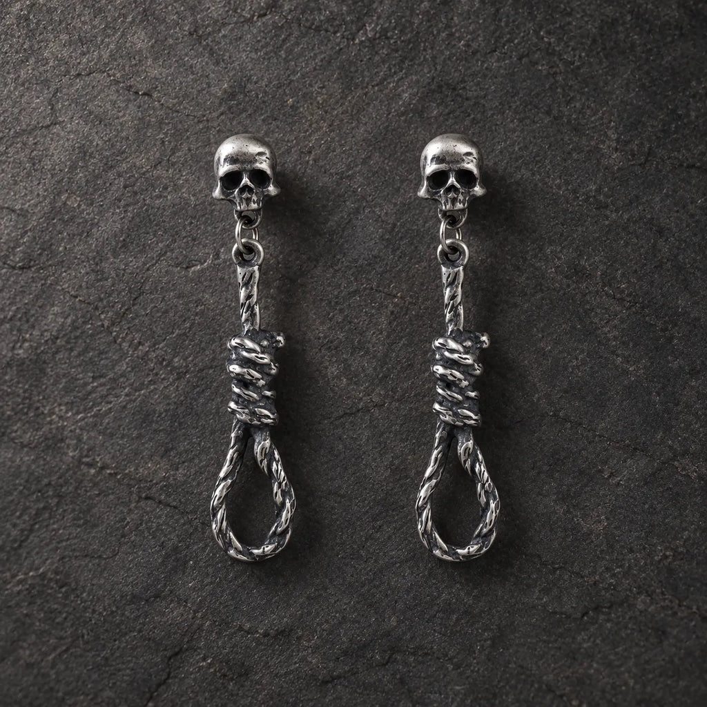 Pair of oxidized 925 sterling silver skull and noose dangle stud earrings on dark stone