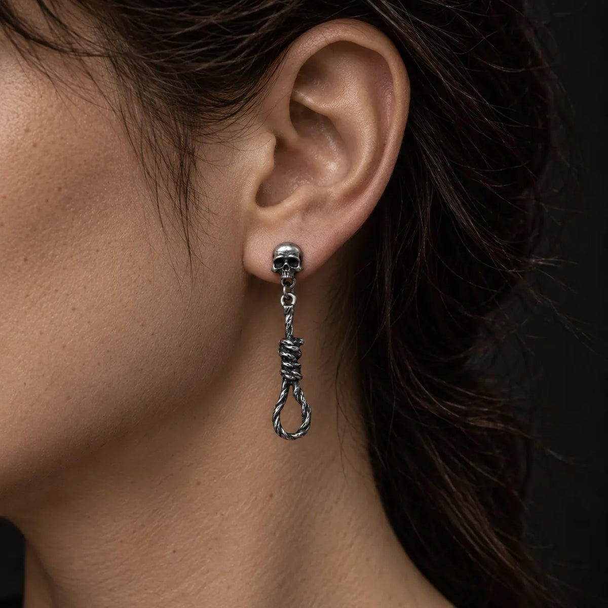 Skull and noose dangle stud earring worn on an ear to show its 43 mm length