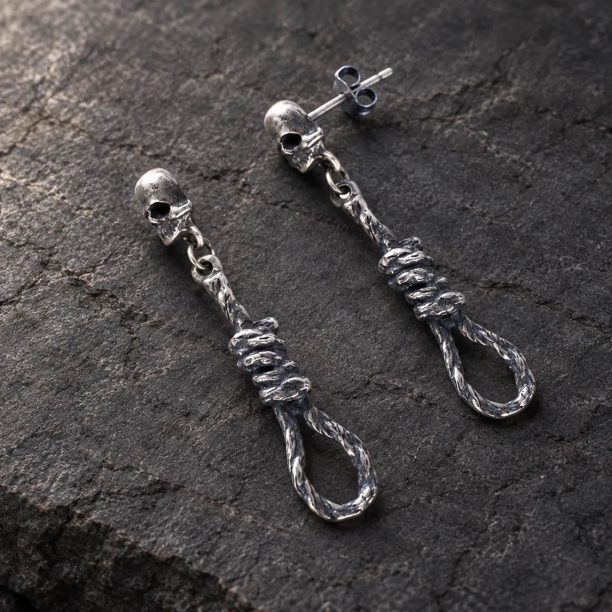 Angled view of skull and noose earrings showing their straight posts and butterfly backs