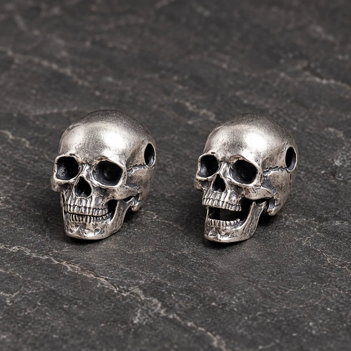 Articulated skull pendant shown with its movable jaw closed and open