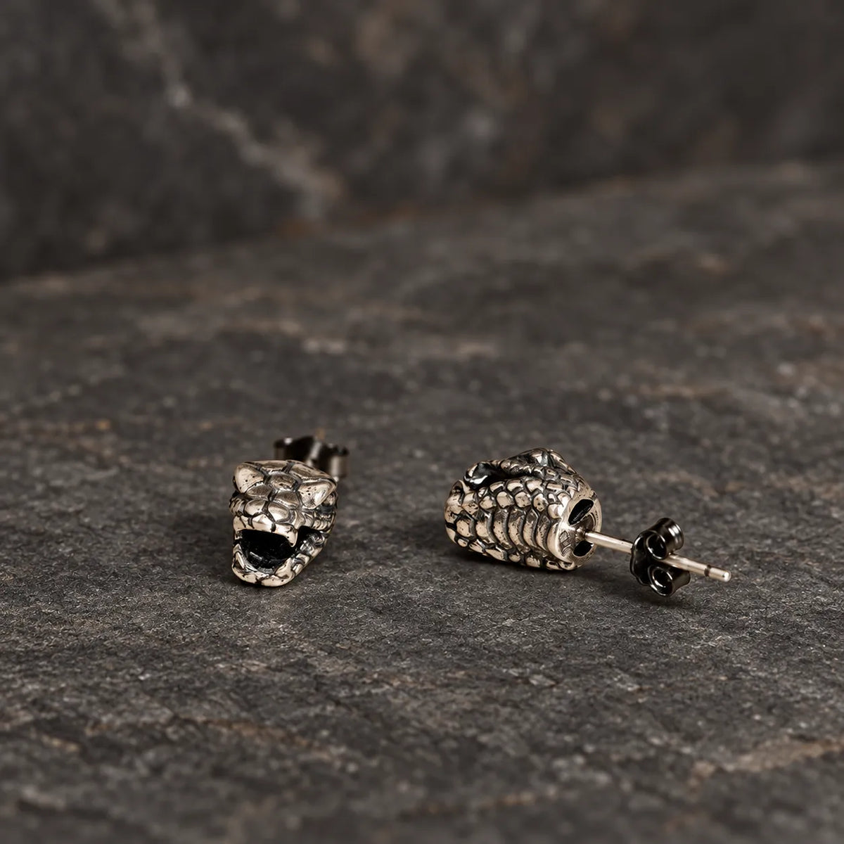 Front and rear-side views of snake head stud earrings showing the post and hollow back