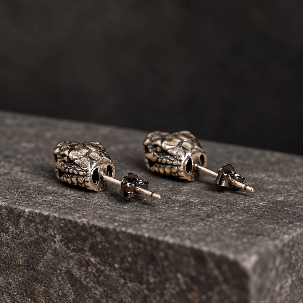 Rear view of serpent head stud earrings showing their hollow backs, straight posts and butterfly closures