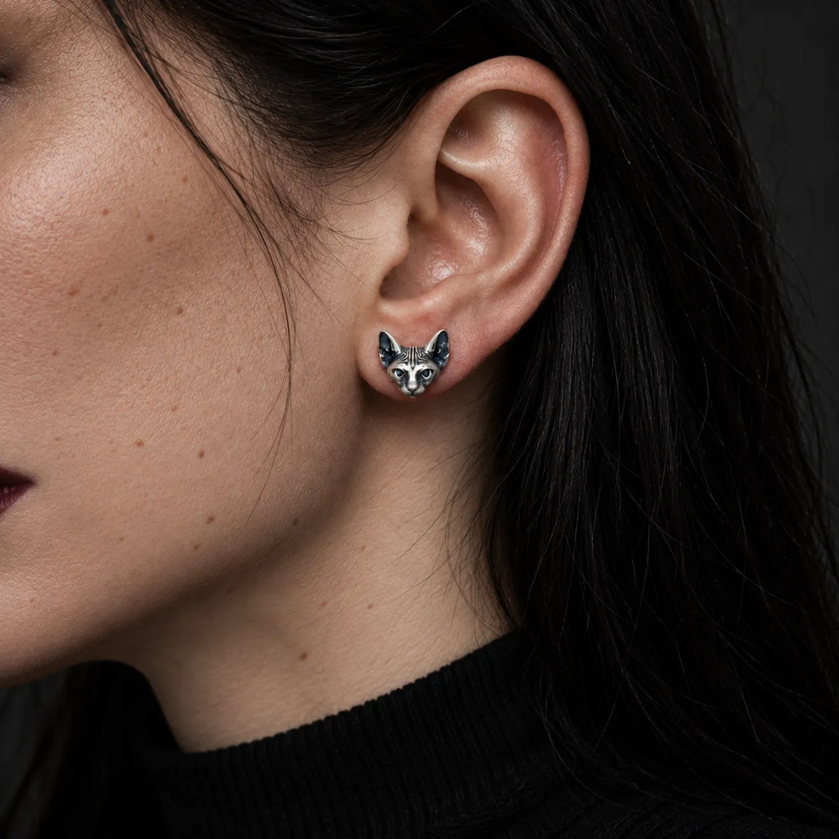 Small silver Sphynx cat stud earring worn to show its actual 10 mm size