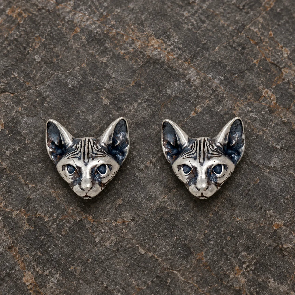 Pair of oxidized sterling silver Sphynx cat stud earrings viewed from the front