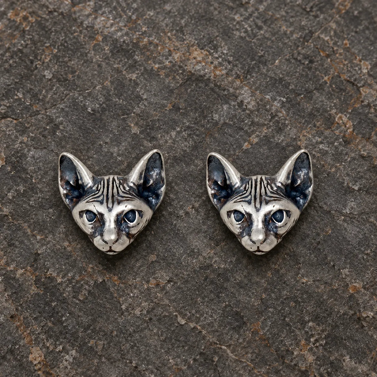 Pair of oxidized sterling silver Sphynx cat stud earrings viewed from the front