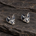 Three-quarter view of sculpted Sphynx cat stud earrings with dark oxidized details