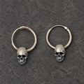 Pair of oxidized sterling silver skull hoop earrings shown from the front