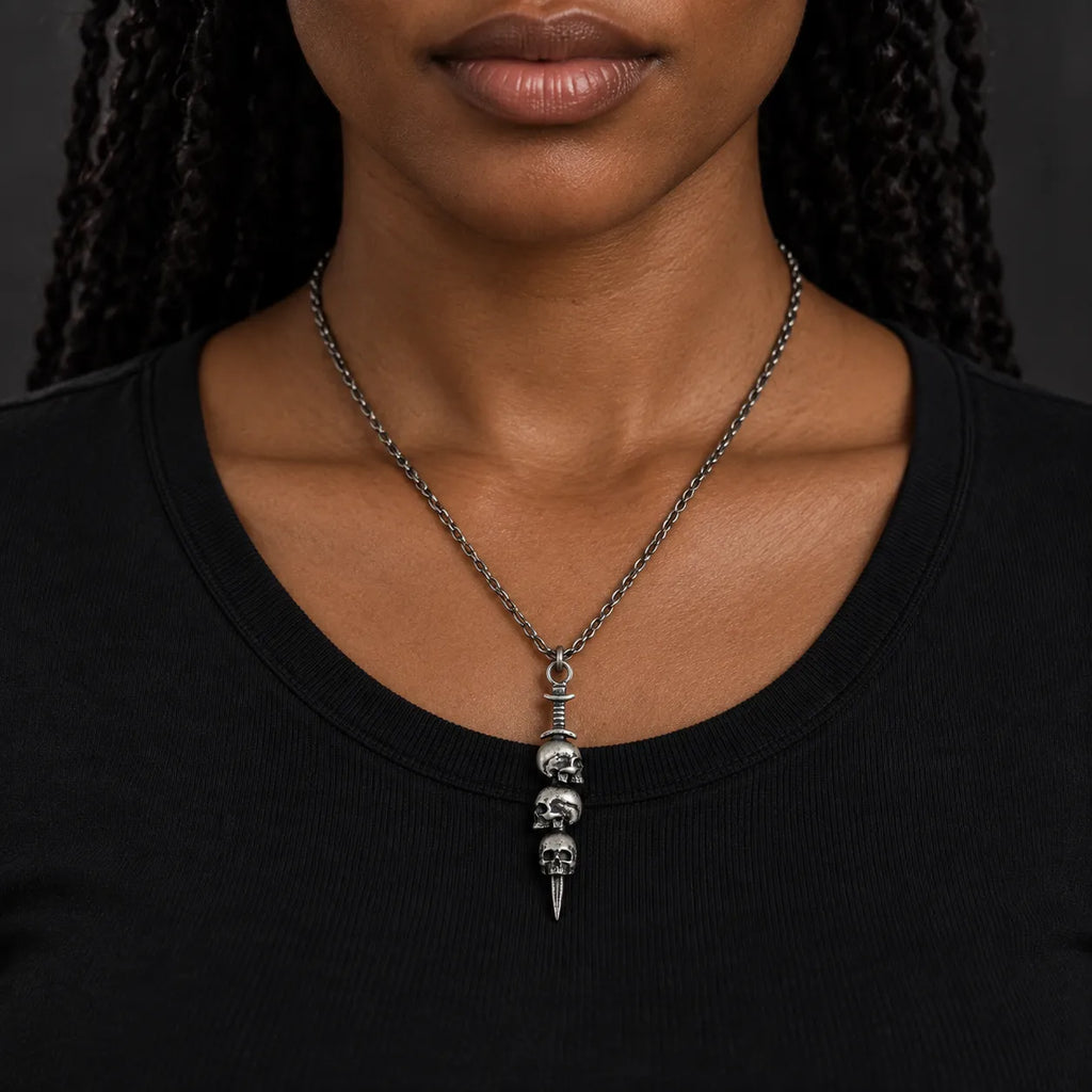 Triple skull dagger pendant worn at its actual 8.5 by 44 mm size on a 2.0 mm chain